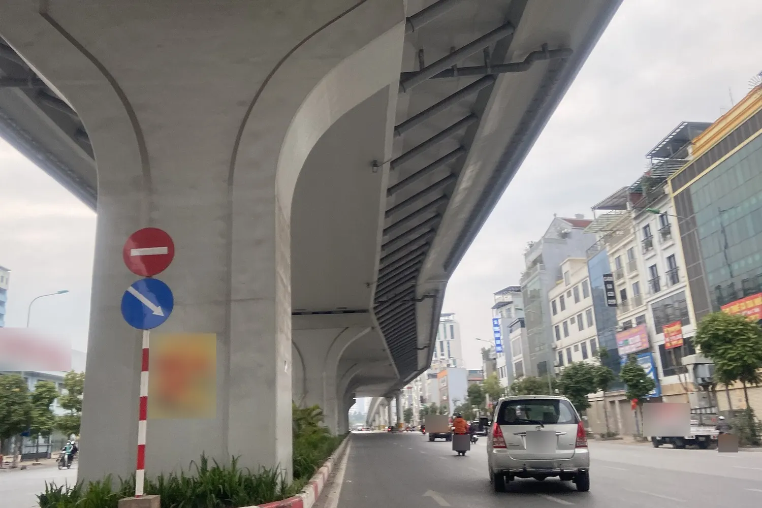 Biển báo cấm đi ngược chiều P.102 (tròn đỏ, vạch ngang trắng) và biển tròn xanh mũi tên chéo trên cột cầu cạn đường Trường Chinh, Hà Nội