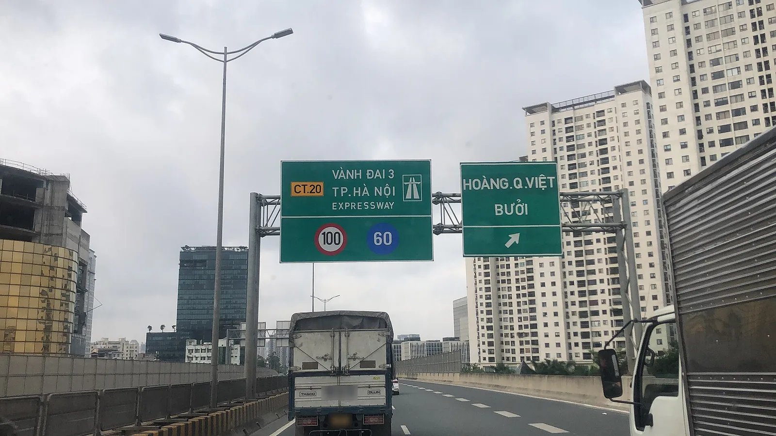 Biển chỉ dẫn nền xanh lá trên cầu cạn Vành đai 3 Hà Nội ghi CT.20, tốc độ tối đa 100 và tối thiểu 60 km/h, bên cạnh biển lối ra Hoàng Quốc Việt