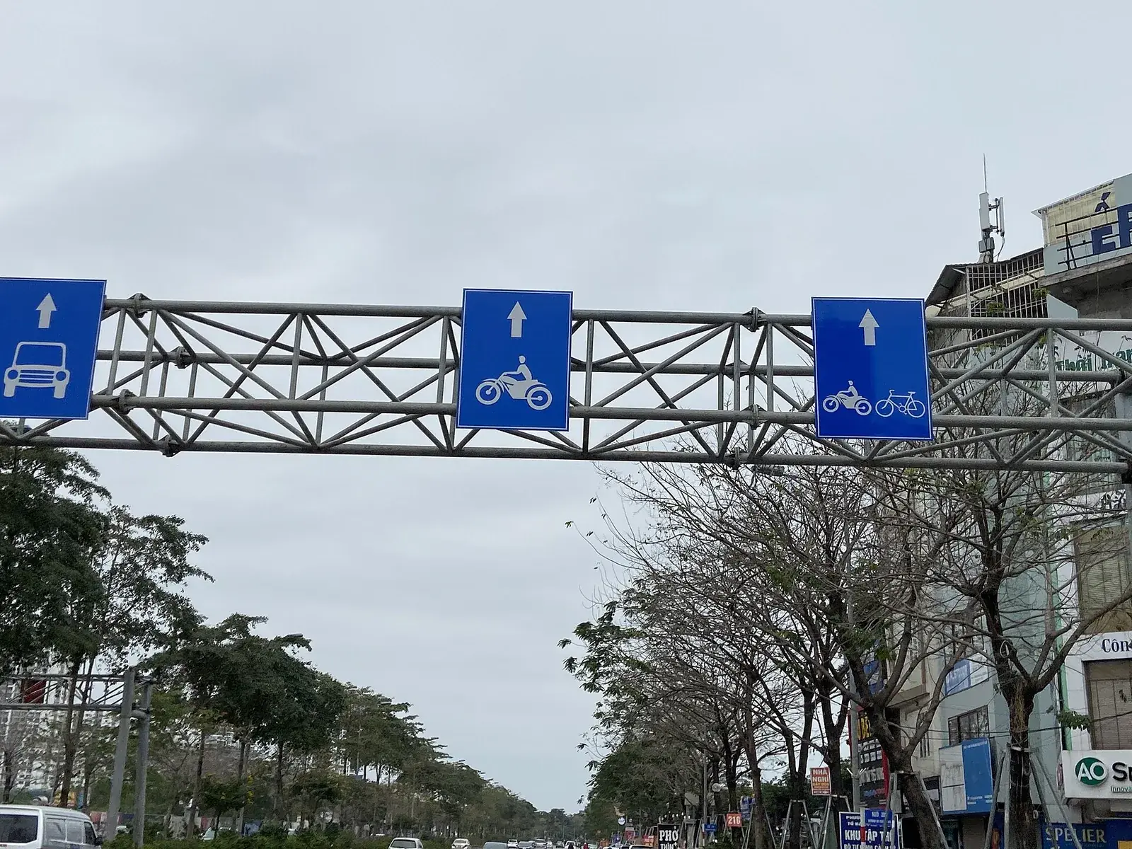 Giá long môn trên đường Võ Chí Công, Hà Nội, treo ba biển chữ nhật nền xanh chỉ làn cho ô tô, làn cho xe máy và làn cho xe máy, xe đạp