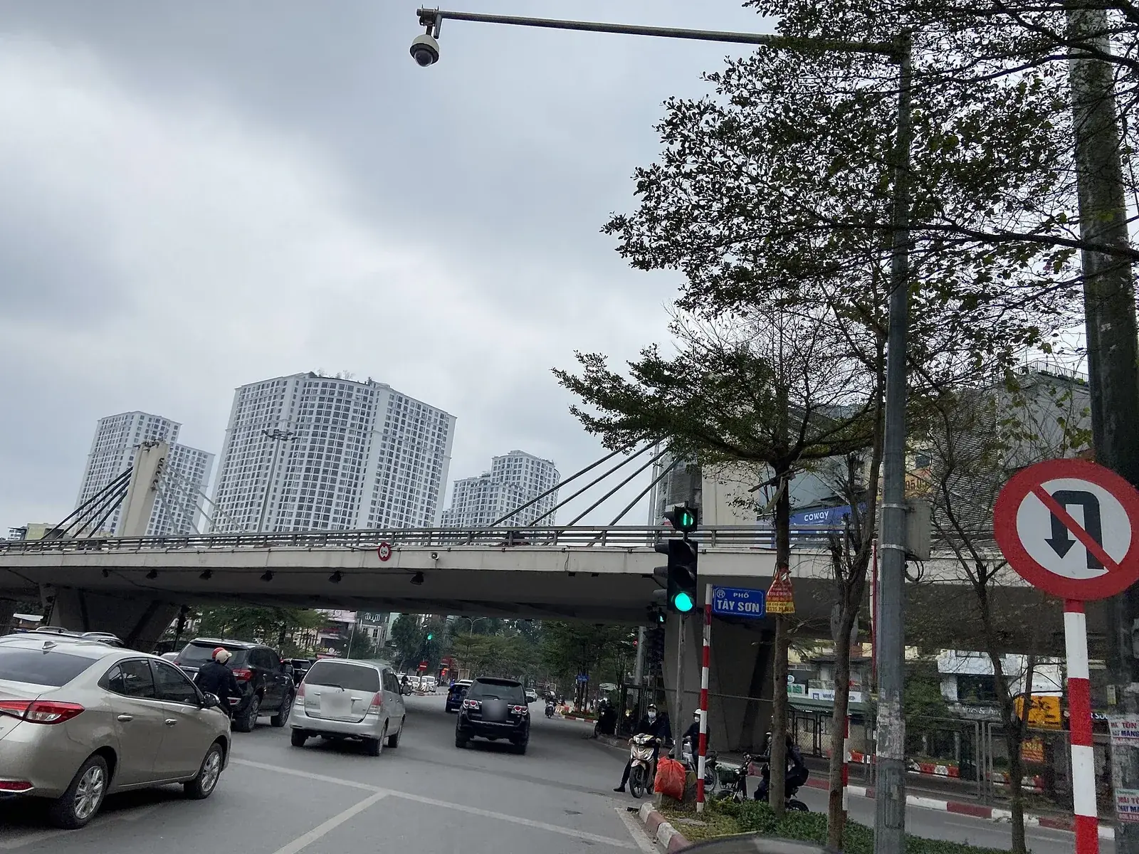 Biển tròn viền đỏ cấm quay đầu xe cắm cạnh đèn tín hiệu ở nút giao đường Trường Chinh, Hà Nội, phía sau là cầu vượt và dòng ô tô