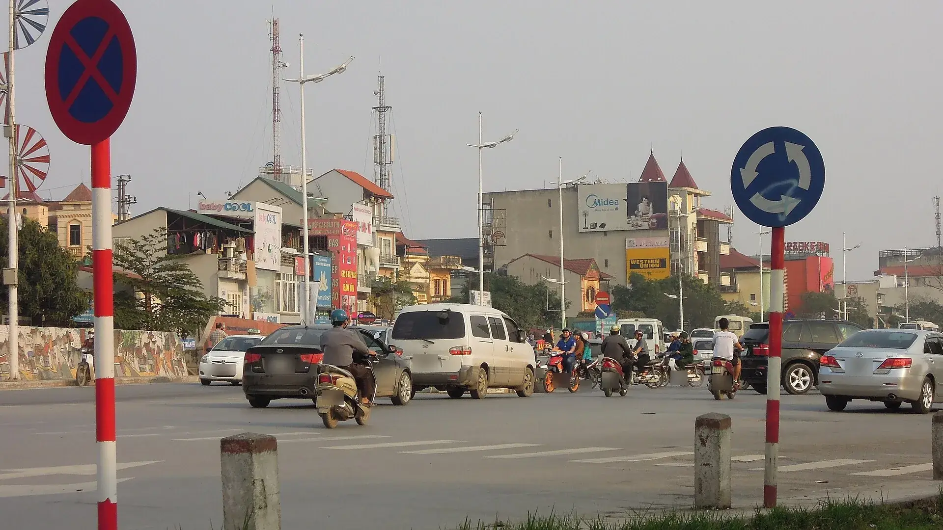Nút giao vòng xuyến ở Hà Nội có biển hiệu lệnh chạy theo vòng xuyến, ô tô và xe máy đang đi vòng
