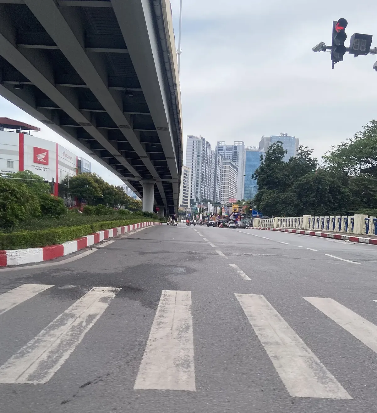 Vạch kẻ cho người đi bộ qua đường dưới cầu cạn tại nút giao Láng – Lê Văn Lương, Hà Nội, đèn tín hiệu đang đỏ ở góc phải